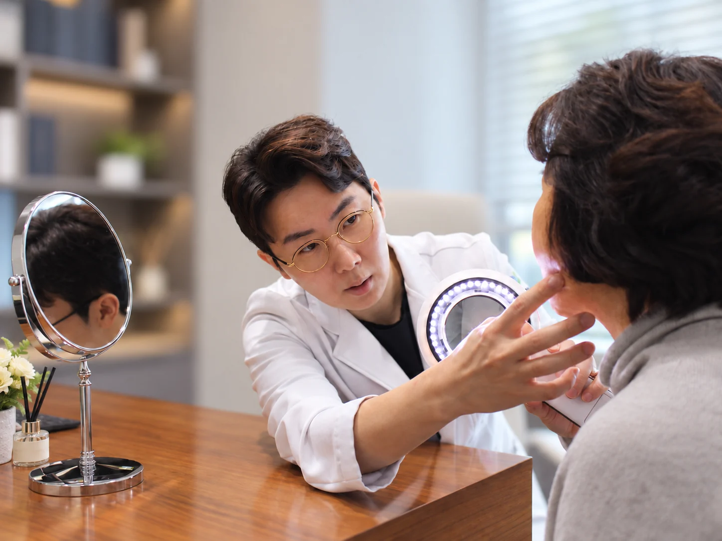 이상근 원장이 환자의 피부를 가까이 살펴보는 모습